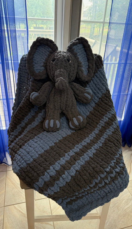 Knitted blanket with a teddy bear toy on a blue surface
