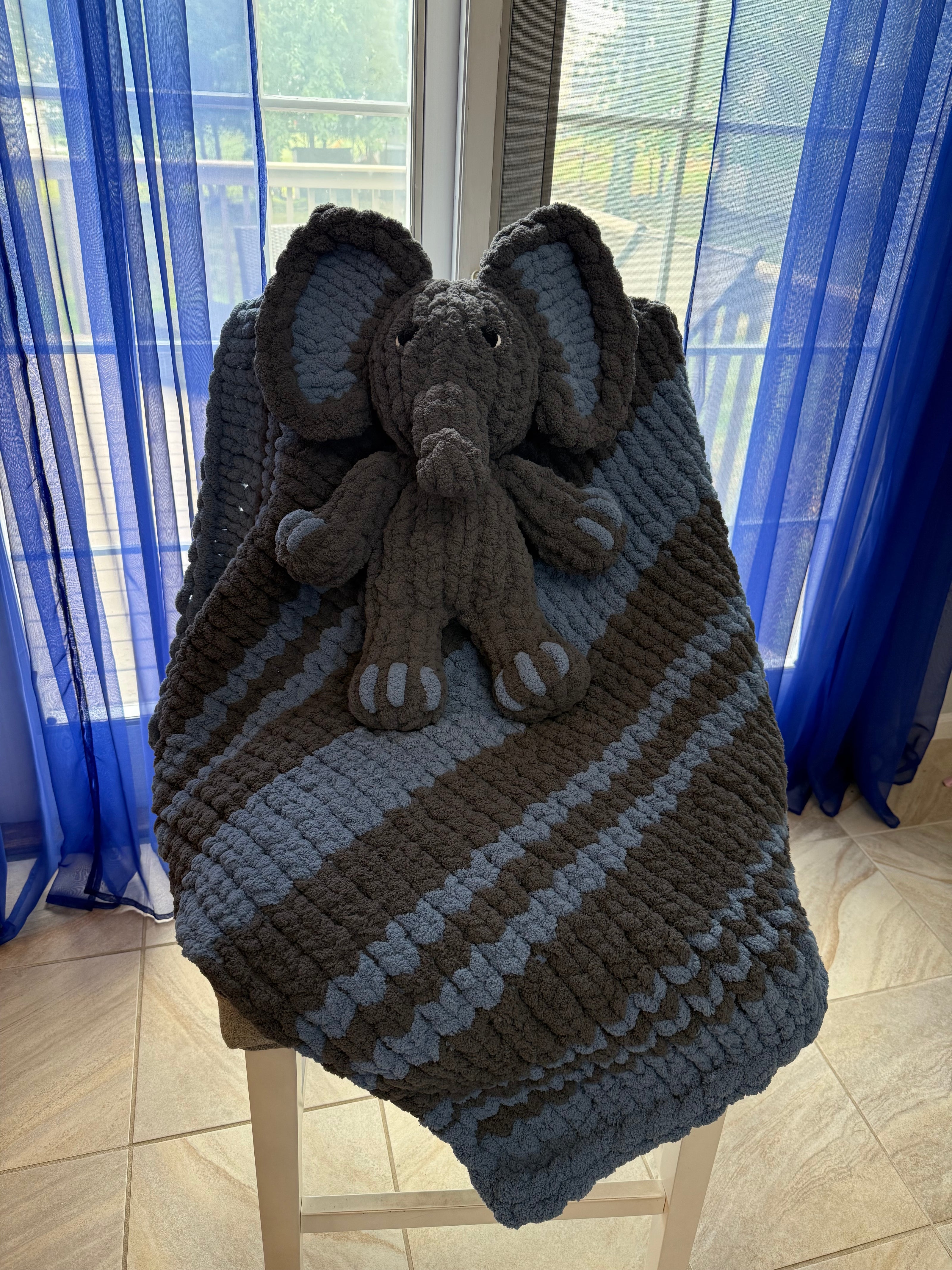 Knitted blanket with a teddy bear on a blue surface