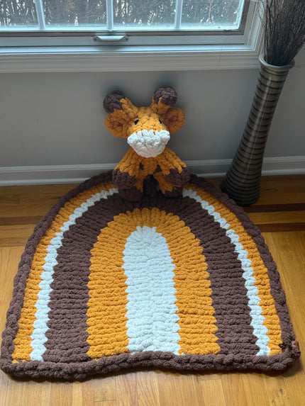 Knitted deer hat with brown, orange, and white stripes on a wooden surface.